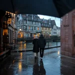 Pluie Strasbourg : parapluie devant une winstub et un musée, rues mouillées